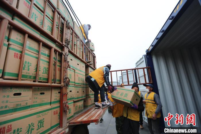 圖為鐵路裝卸作業(yè)人員正在將云南特色農(nóng)產(chǎn)品裝入集裝箱?！詈?攝
