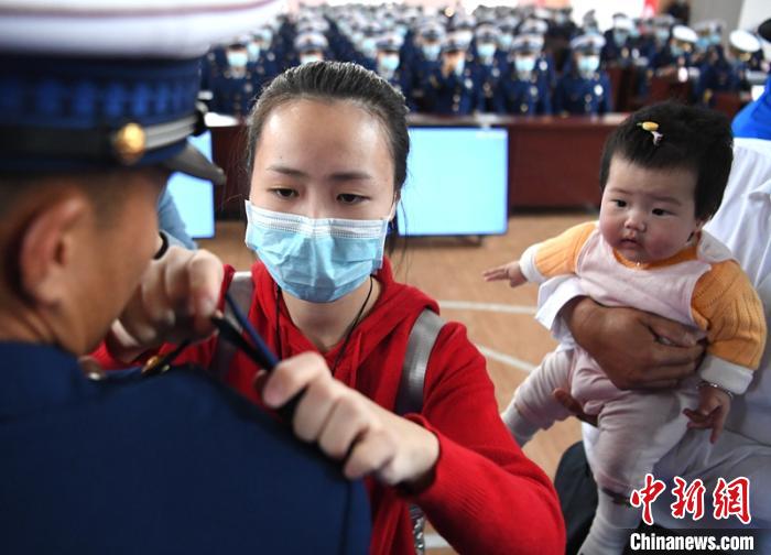 新消防員楊振的妻子彭莉與女兒現(xiàn)場(chǎng)見(jiàn)證丈夫加入“火焰藍(lán)”的神圣時(shí)刻?！⒅铱?攝