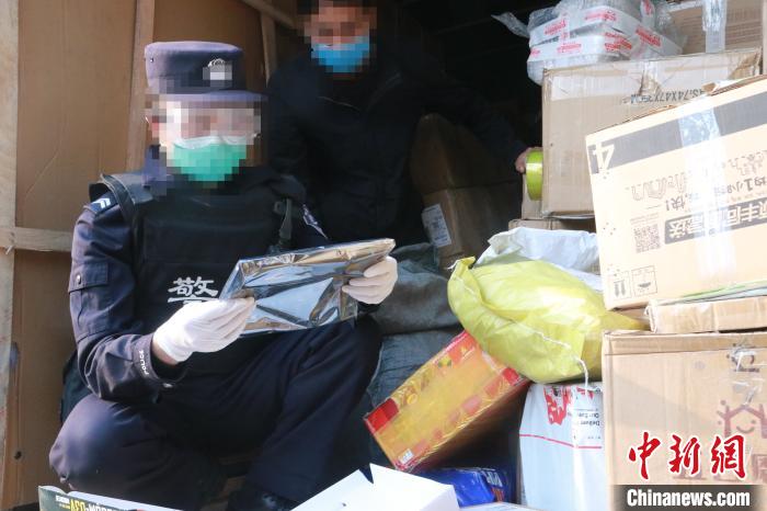 圖為勐康邊檢站民警在對(duì)快遞運(yùn)輸車輛進(jìn)行例行檢查。　楊添 攝