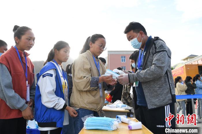 7月7日，考生在拉薩三高考點(diǎn)外領(lǐng)取口罩?！『闻罾?攝
