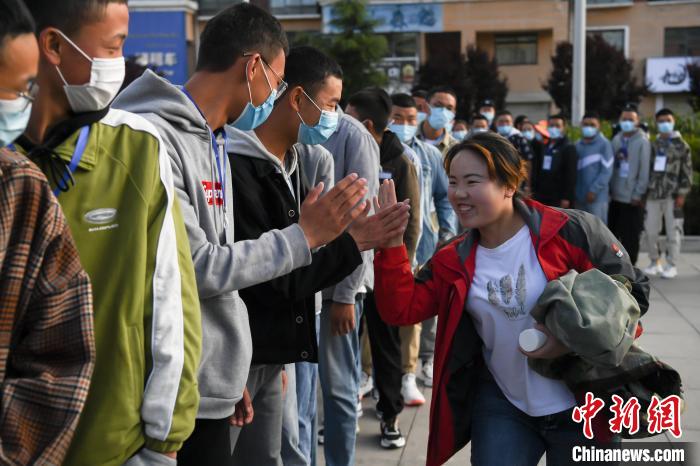 7月7日，拉薩三高考點(diǎn)外，領(lǐng)隊(duì)老師與考生擊掌鼓勁加油。　何蓬磊 攝