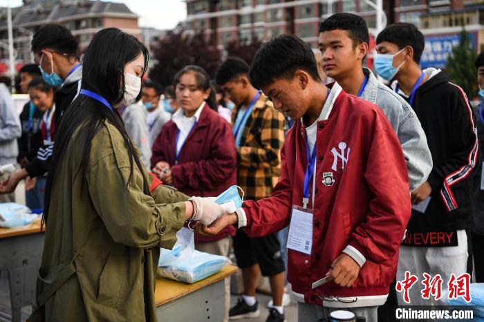 7月7日，考生在拉薩三高考點(diǎn)外測量體溫?！『闻罾?攝