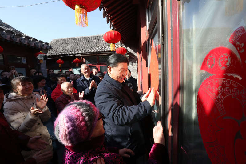 2019年2月1日上午，習(xí)近平在北京前門東區(qū)草廠四條胡同32號院，高興地拿起一幅“?！弊郑H自貼到門上，給這里的老街坊們拜年。新華社記者 鞠鵬 攝