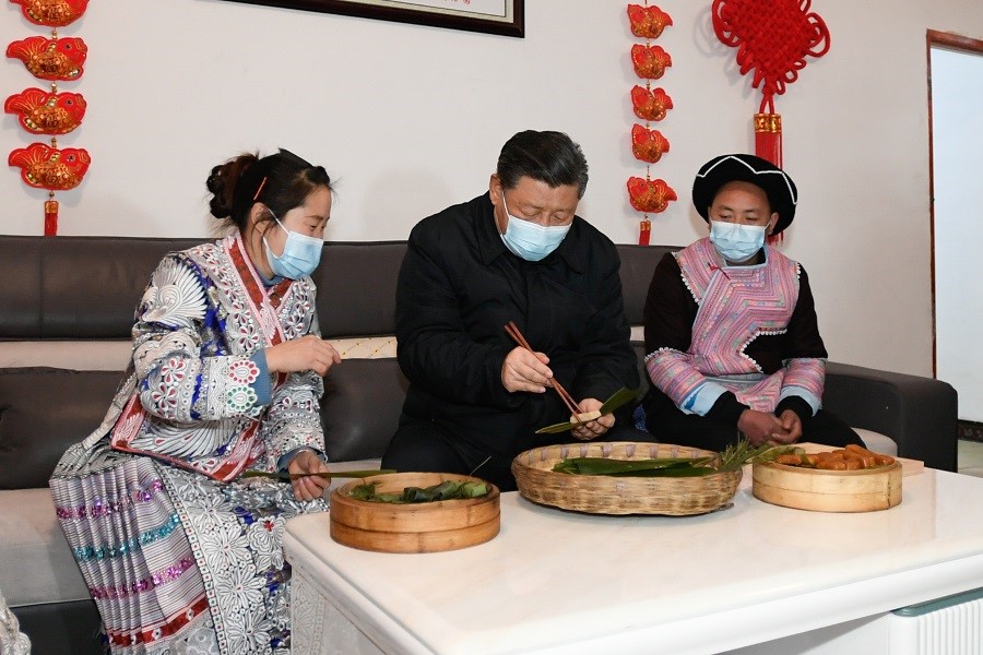 2021年2月3日下午，習(xí)近平在貴州畢節(jié)市黔西縣新仁苗族鄉(xiāng)化屋村苗族村民趙玉學(xué)家，同一家人邊聊家常邊制作當(dāng)?shù)貍鹘y(tǒng)節(jié)日食品黃粑。新華社記者 李學(xué)仁 攝